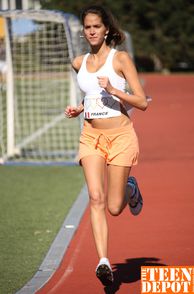 Coed Girl Running On The Track